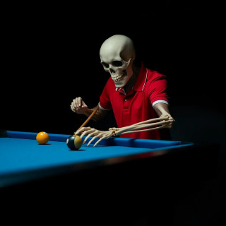 A person with a skull mask is playing billiards.  The subject, appearing middle-aged, is positioned in the mid-ground, slightly angled toward the right side of the image, and centered horizontally within the frame.  The skull mask is a light beige color, and the person is wearing a red polo shirt with a white collar. The figure's arms and hands are skeletal in appearance, articulated with visible bone structure. The figure's body type appears lean and muscular. The subject is aiming a pool cue at two billiard balls.  The billiards table is a deep blue color, and the lighting is focused on the figure and the action. The composition is tightly framed, concentrating the viewer's attention on the striking action.  The atmosphere is dark, dramatic, and slightly morbid, focusing on the surreal contrast of the skeletal form and the game.  Two billiard balls, one yellow, one red, are visible on the table.  The style is photorealistic with stylized elements, enhancing the surreal theme.